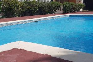 une grande piscine bleue en face d'un bâtiment dans l'établissement Juan Dolio - Hermoso y acogedor apartamento, à Juan Pedro