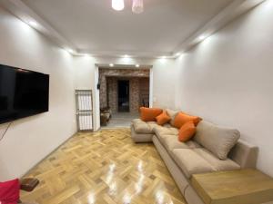 uma sala de estar com um sofá e uma televisão de ecrã plano em Superior Apartment on Kostava em Tbilisi