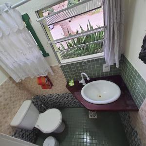 een badkamer met een wastafel, een toilet en een raam bij Pousada Quintal Verde Floripa in Florianópolis