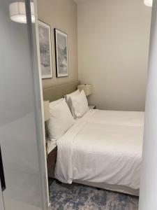 a bedroom with a bed with white sheets and pillows at Apartment the address resort- Two-Bedroom and maid room in Al Aqah +9 photos