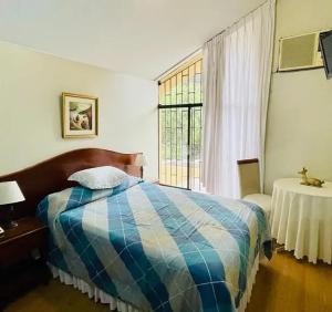 1 dormitorio con cama y ventana en Villas Del Sol Bed & Breakfast en Lima