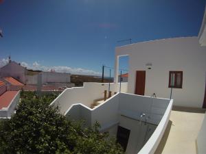 - un bâtiment blanc avec des escaliers sur son côté dans l'établissement Ahoy Porto Covo Hostel, à Porto Covo