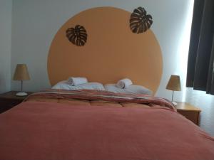 a bedroom with a large red bed with two lamps at Social Hostel Café e Bar in Curitiba