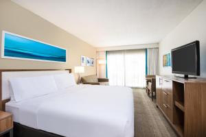 a hotel room with a bed and a flat screen tv at Holiday Inn Resort Aruba - Beach Resort & Casino, an IHG Hotel in Palm-Eagle Beach