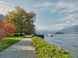 a path next to a body of water with a boat at Nona lakeside apt at patrician Villa in Bellagio