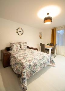 a bedroom with a bed with a clock on the wall at Le Joyau T2-55m2 Centre ville 10min Disney in Bussy-Saint-Georges