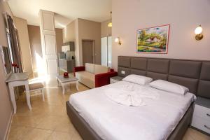 a bedroom with a large bed and a living room at Apartments Serxhio in Sarandë