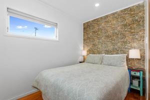 a bedroom with a bed and a window at Matapouri Magic - Matapouri Holiday Home in Matapouri
