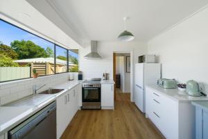 a kitchen with white appliances and a large window at Greytown Getaway - Greytown Holiday Home in Greytown