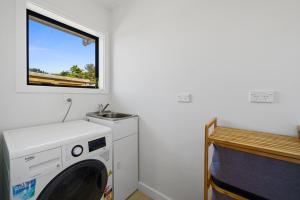 a washing machine in a room with a window at Greytown Getaway - Greytown Holiday Home in Greytown