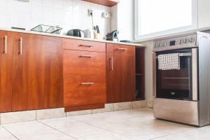 a kitchen with wooden cabinets and a stainless steel refrigerator at Panorama View Budget Apartment in Veszprém