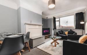 uma sala de estar com um sofá e uma mesa em BEST PRICE! Perfect Gunwharf Accommodation - 5 single beds or Kingsize FREE PARKING em Portsmouth