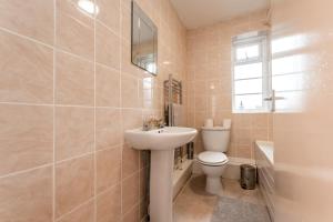a bathroom with a white sink and a toilet at BEST PRICE! Perfect Gunwharf Accommodation - 5 single beds or Kingsize FREE PARKING in Portsmouth