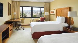 a hotel room with two beds and a desk at InterContinental Jordan, an IHG Hotel in Amman