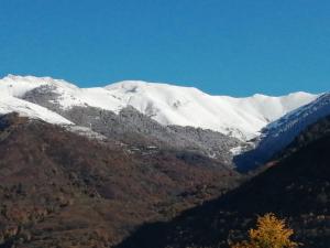 a snow covered mountain with trees in front of it at Ski Bagnères-de-Luchon in Luchon +5 photos
