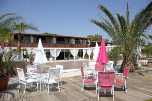 a group of tables and chairs on a deck at Beach Club Ippocampo in Ippocampo