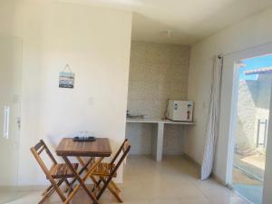a room with a table and two chairs and a kitchen at Gold Star Village Kitnet equipado in Majorlândia