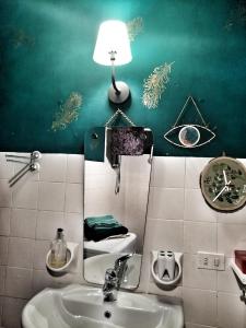 un bagno con lavandino e lampada a muro di RaMaya casa d'artista 2 a Biella