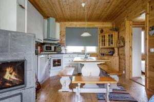 a kitchen with a table and a fireplace at Cottage Kivitatti in Sysmä