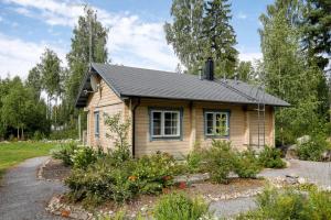 een klein houten huis met een tuin ervoor bij Cottage Kivitatti in Sysmä