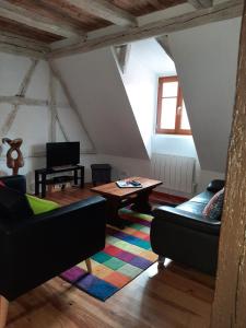 ein Wohnzimmer mit 2 Sofas und einem Tisch in der Unterkunft Les Epicuriens du Rempart in Eguisheim