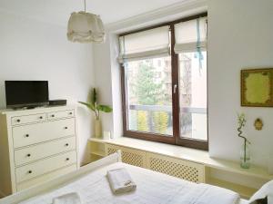 Schlafzimmer mit einem Bett und einem Fenster in der Unterkunft Warsaw Concierge Vistula Apartment in Warschau
