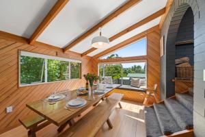 ein Esszimmer mit einem Tisch und einigen Fenstern in der Unterkunft Choice Wharewaka - Taupo Holiday Home in Taupo