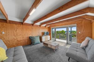 ein Wohnzimmer mit einem Sofa und einem Tisch in der Unterkunft Choice Wharewaka - Taupo Holiday Home in Taupo