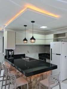 アキラスにあるAp Aquaville resort -CEのキッチン(黒いカウンター、白い冷蔵庫付)