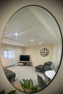a mirror reflecting a living room with a tv at Seaview Luxury Apartments in Redcar
