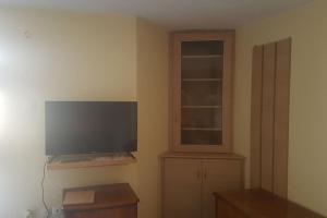 a living room with a flat screen tv and a window at Rena's house in Pachia Ammos