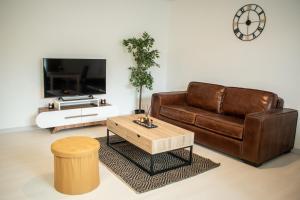 a living room with a brown couch and a coffee table at Le Joyau T2-55m2 Centre ville 10min Disney in Bussy-Saint-Georges