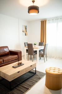 a living room with a couch and a table at Le Joyau T2-55m2 Centre ville 10min Disney in Bussy-Saint-Georges