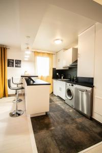 a kitchen with white cabinets and a washer and dryer at Le Joyau T2-55m2 Centre ville 10min Disney in Bussy-Saint-Georges