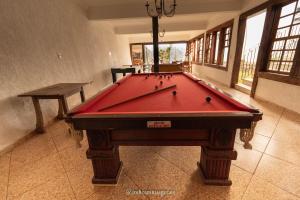 a pool table in a room with a red cloth at Pouso Tiradentes in Tiradentes