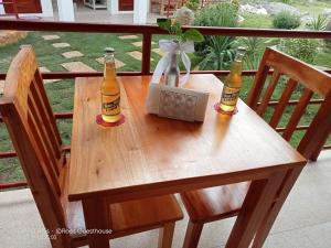 dos botellas de cerveza sentadas en una mesa de madera en Roos Guesthouse en Moalboal