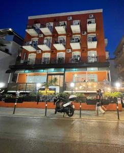 Hotel Venere في ريميني: دراجة نارية متوقفة أمام مبنى في الليل