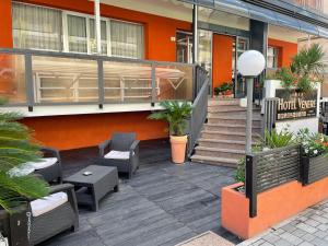 un patio con sedie e tavoli e un edificio di Hotel Venere a Rimini