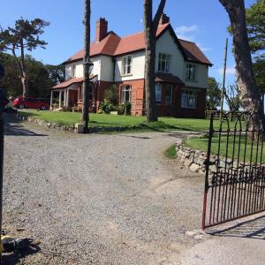 uma casa com um portão em frente em The Old Vicarage NI B&B em Ballywalter