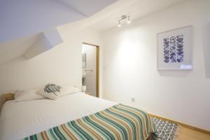 リスボンにあるCatchy @ Campo Pequenoのベッドルーム1室(ストライプ毛布付きのベッド1台付)