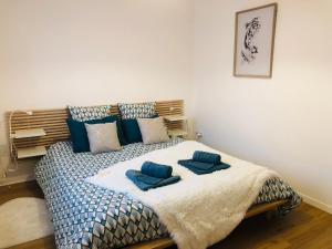 Un dormitorio con una cama con almohadas azules. en Maison La Baliere,2 chambres,5 personnes, à 20 minutes du Puy du Fou, en Pouzauges