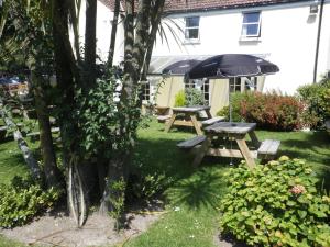 a picnic table and an umbrella in a yard at Longfrie Inn in St Saviour Guernsey