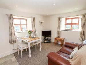 uma sala de estar com um sofá e uma mesa em Drover's Cottage em Wolsingham