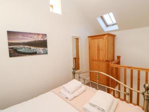 a small bedroom with a bed and a staircase at Drover's Cottage in Wolsingham