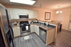 a kitchen with white cabinets and a black refrigerator at Cozy Renovated Winder Townhouse in Winder