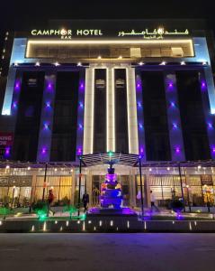 un bâtiment avec une fontaine devant lui la nuit dans l'établissement Camphor Hotel, à Ras al Khaimah