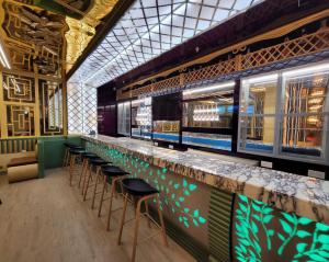 un bar con una fila de taburetes en un restaurante en Camphor Hotel, en Ras al Khaimah
