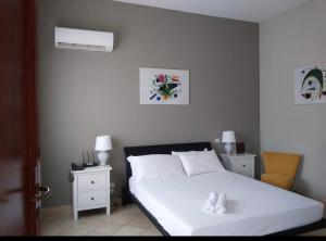 a bedroom with a white bed and two night stands at Colonna Rooms & apartment in Trani