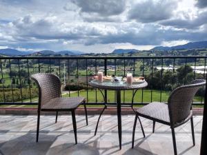 a table and two chairs on a balcony with a view at Sierra Morena in Cogua