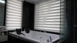 baño con 2 lavabos y bañera con ventanas en Sierra Morena, en Cogua